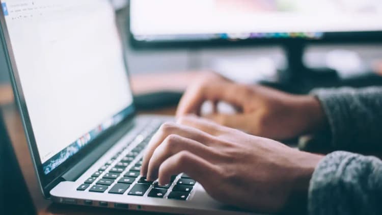 Persona trabajando en un portátil, planificando un sitio web de bufete de abogados efectivo